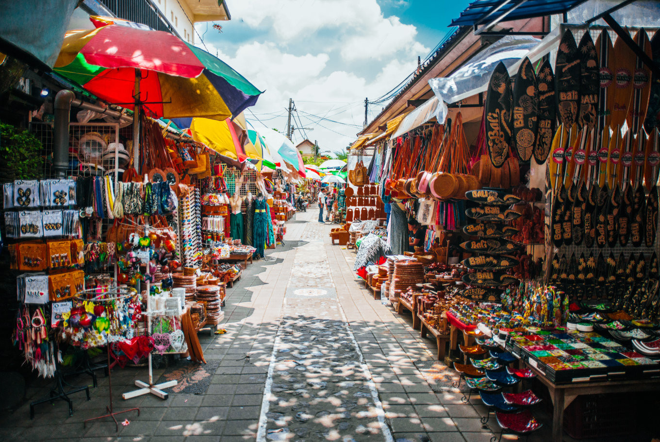 Bustling scene at a Canggu market, showcasing vibrant stalls and happy shoppers, with Masmara Resort Canggu as the ideal place to stay nearby.