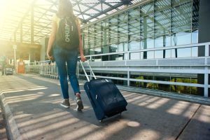 An open suitcase filled with neatly packed clothes, travel essentials, and a hat, ready for a Bali adventure.